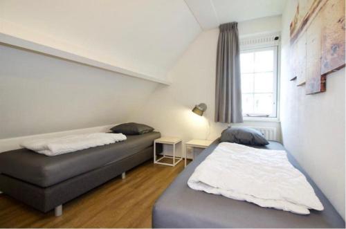 a bedroom with two beds and a window at Modern Vakantiehuis op Loopafstand van de Zee in Kamperland in Kamperland