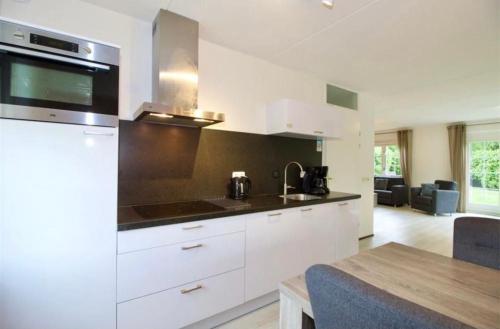 a kitchen with white cabinets and a counter top at Modern Vakantiehuis op Loopafstand van de Zee in Kamperland in Kamperland