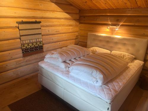 ein Schlafzimmer mit einem Bett in einem Blockhaus in der Unterkunft Timber Lodge in Uvdal Skisenter VIEW/WIFI in Sønstebø