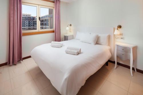 a large white bed in a room with a window at Boliches Mediterraneo Real Tropical Coast by Alfresco Stays in Las Lagunas Mijas