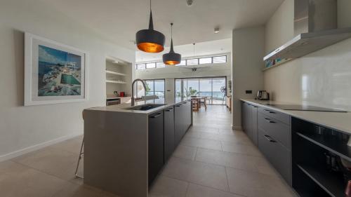 a kitchen with a sink and a counter top at Beach front penthouse in Pereybere in Grand Baie