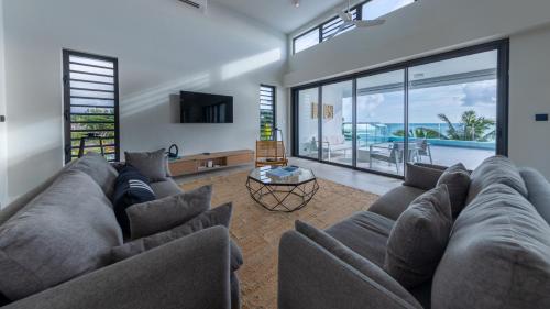 a living room with a large couch and a table at Beach front penthouse in Pereybere in Grand Baie