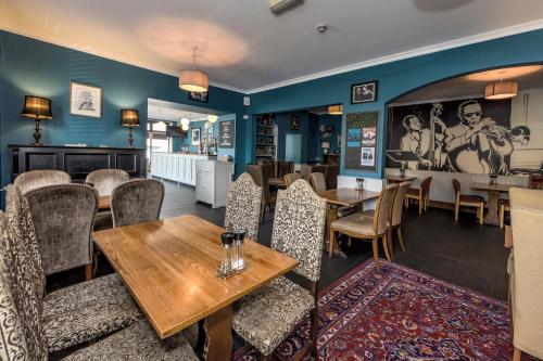 ein Restaurant mit Tischen und Stühlen und eine Bar in der Unterkunft The Cornerhouse in Frome