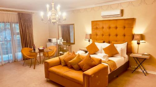 a bedroom with a large bed and a couch at 27A on Angus in Johannesburg