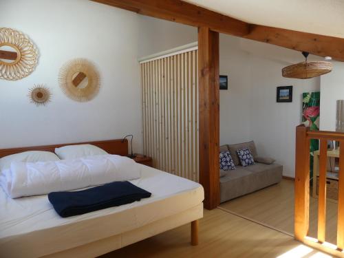 1 dormitorio con cama y sofá en HENDAYE PLAGE Logement entier avec jardin, en Hendaya
