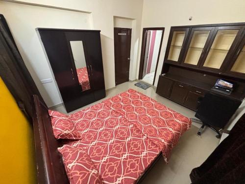 a bedroom with a bed with a red comforter at Kiran parks 101 in Hyderabad