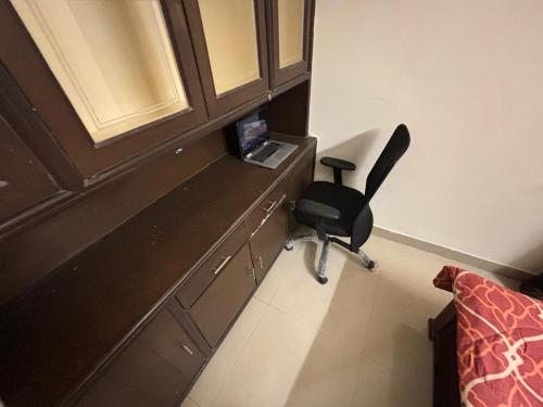 a room with a desk with a chair next to a bed at Kiran parks 101 in Hyderabad