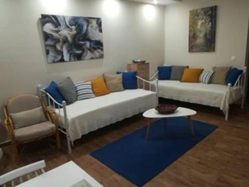 a living room with two white couches and a blue rug at Garden in Almirón