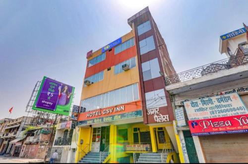 un edificio alto con muchas señales delante de él en Gsv hotel, en Kānpur