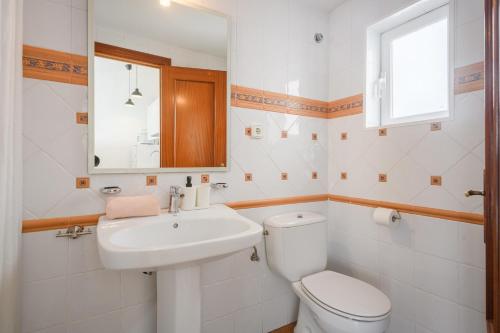 ein weißes Bad mit einem WC und einem Waschbecken in der Unterkunft CHIC APARTAMENTS in Tossa de Mar