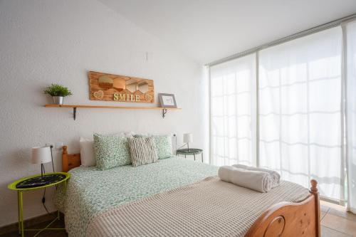 ein Schlafzimmer mit einem Bett und einem großen Fenster in der Unterkunft CHIC APARTAMENTS in Tossa de Mar