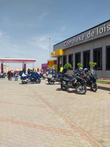 een groep motorfietsen geparkeerd voor een gebouw bij Complex Amazon Guercif in Guercif