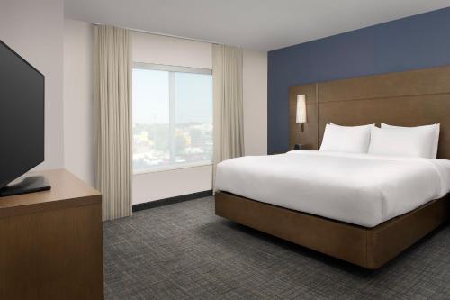 a bedroom with a large bed and a large window at Residence Inn by Marriott Lubbock-University Area in Lubbock