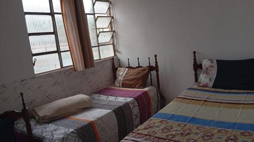 een kamer met 2 bedden en 2 ramen bij Hotel Pinheiros in Pinheiros