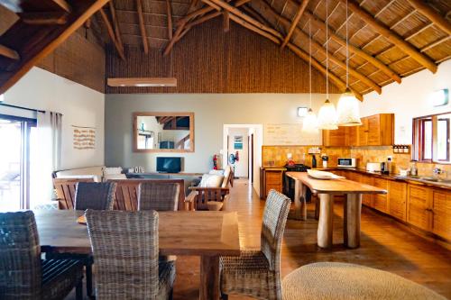 a kitchen and dining room with a wooden table and chairs at Sia Sente Beach estate in Inhambane