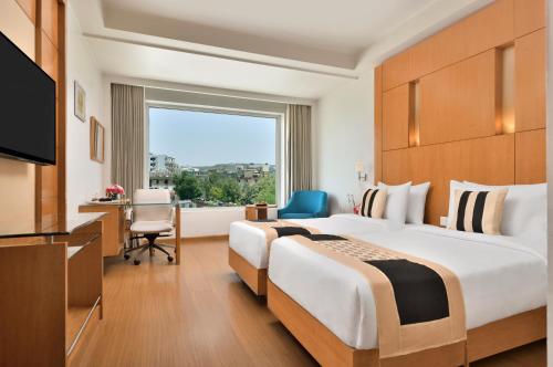 a hotel room with a large bed and a window at Ramada By Wyndham Jaipur in Jaipur