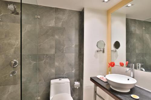 La salle de bains est pourvue de toilettes, d'un lavabo et d'une douche. dans l'établissement Ramada By Wyndham Jaipur, à Jaipur
