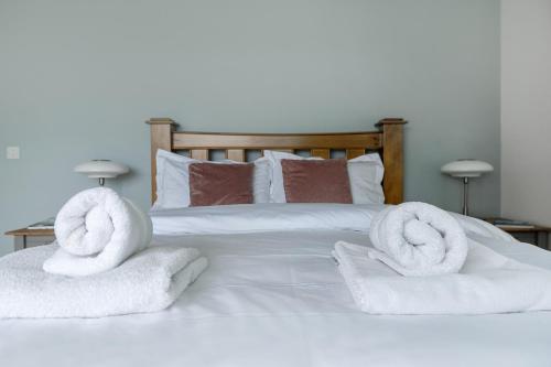 a bed with white towels on top of it at Patch House Glengarriff in Glengarriff
