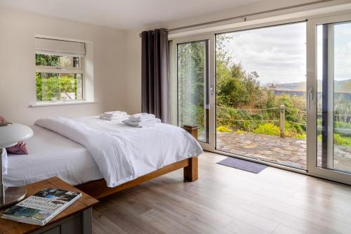 a bedroom with a bed and a large window at Patch House Glengarriff in Glengarriff