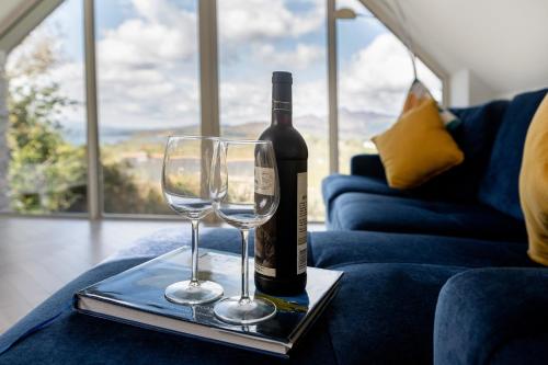a bottle of wine and two wine glasses on a tray at Patch House Glengarriff in Glengarriff