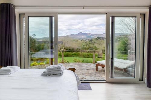 a bedroom with two beds and a large glass window at Patch House Glengarriff in Glengarriff