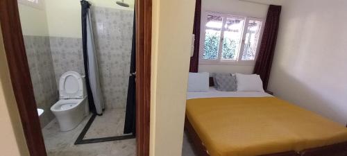 Habitación pequeña con cama y aseo en Ancha's Oasis en Maputo