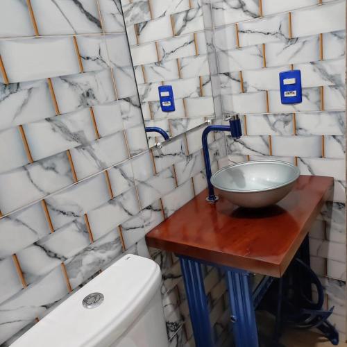a bathroom with a bowl on a table next to a sink at HospedaAurora Casa 3 quartos com ar in Manhã