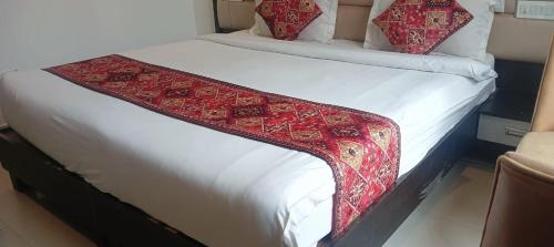 un letto con una coperta rossa e bianca sopra di INN AVI HOTEL 100 Meter from Golden Temple ad Amritsar