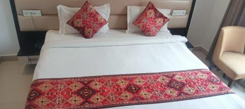 un letto con una coperta rossa e bianca sopra di INN AVI HOTEL 100 Meter from Golden Temple ad Amritsar