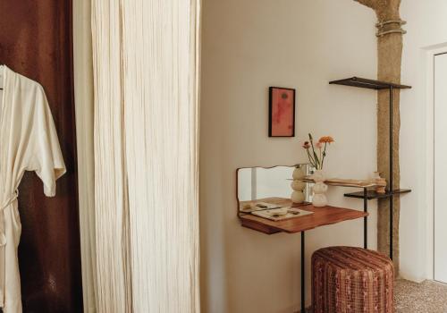 a room with a mirror and a table with a stool at Mona Athens in Athens