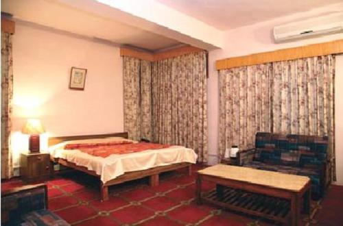 パランプールにあるHotel Starry Nightのベッドルーム1室(ベッド1台、テーブル、ソファ付)