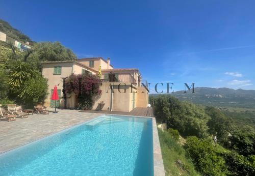 a villa with a swimming pool and a house at Villa ALTORE in Calenzana