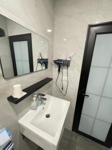 ein Badezimmer mit einem weißen Waschbecken und einem Spiegel in der Unterkunft 橋燈民宿 in Hsin-hua
