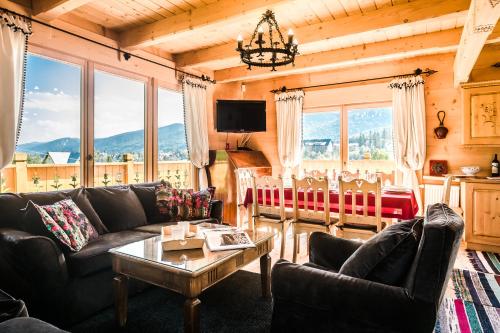 a living room with a couch and a table at TatryTop Osada Luxury Chalets Kościelisko in Kościelisko