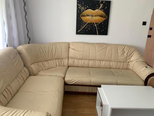 un sofá de cuero blanco en la sala de estar en Apartament închiriere, en Târgovişte