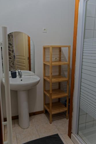 La salle de bains est pourvue d'un lavabo, d'un miroir et d'une étagère. dans l'établissement Oustal, à Argentat