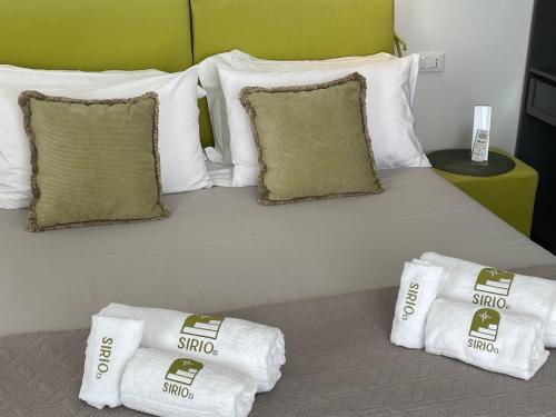 1 cama grande con almohadas blancas y toallas. en Stanza Sirio13, en Tricase