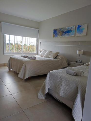 two beds in a white room with a window at HOTEL PARADOR 9 in San Marcos