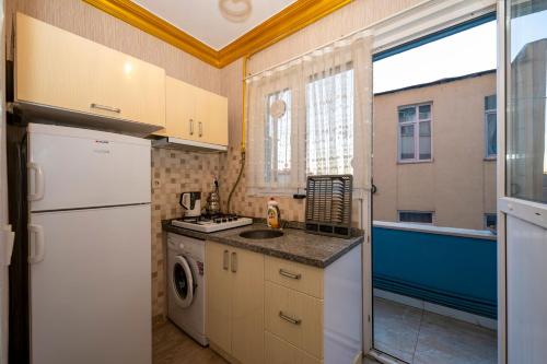 a small kitchen with a white refrigerator and a window at Sweet Home in Istanbul