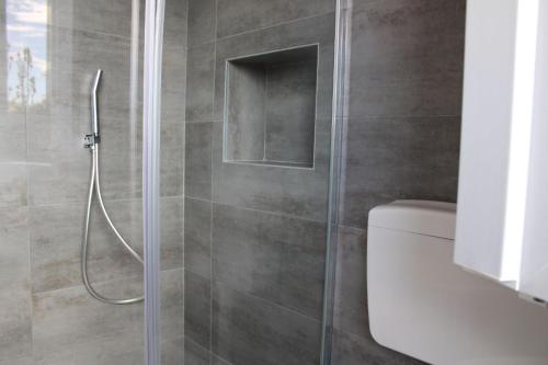 a shower with a glass door in a bathroom at la Luna Blu Malpensa camera matrimoniale Diamante in Somma Lombardo