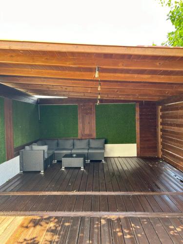 a patio with couches on a wooden deck at Platán Panzió in Csongrád
