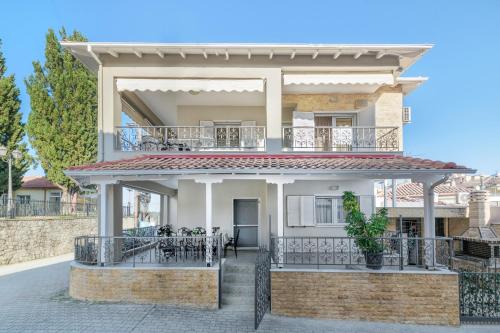 a villa with a balcony in front of it at Nasia House Paliouri in Paliouri
