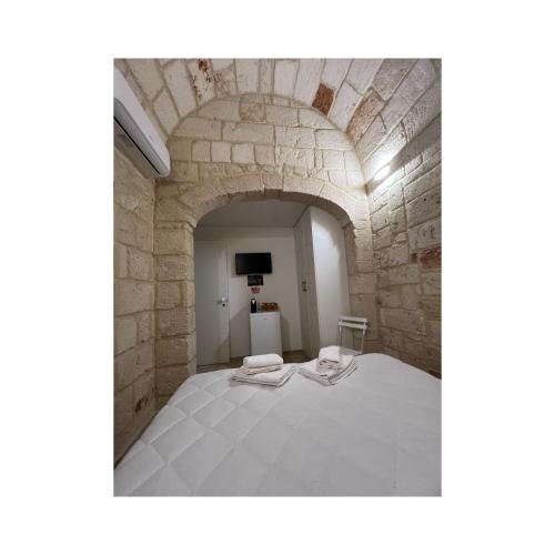 a bedroom with a bed in a stone wall at Locus Amoenus in Polignano a Mare