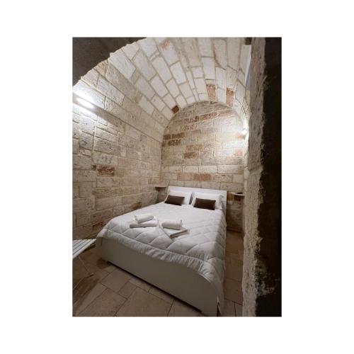 a bedroom with a bed in a brick wall at Locus Amoenus in Polignano a Mare