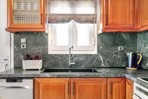 a kitchen with wooden cabinets and a sink at Nasia House Paliouri in Paliouri