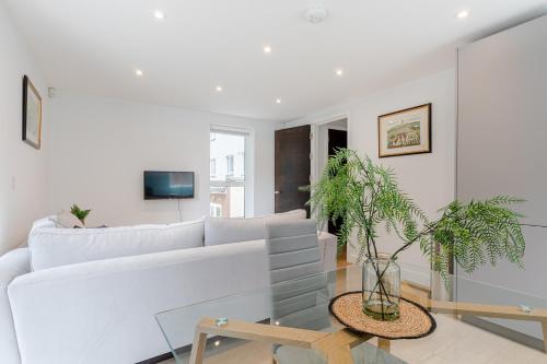 sala de estar con sofá blanco y mesa de cristal en StayInn Aldgate, en Londres