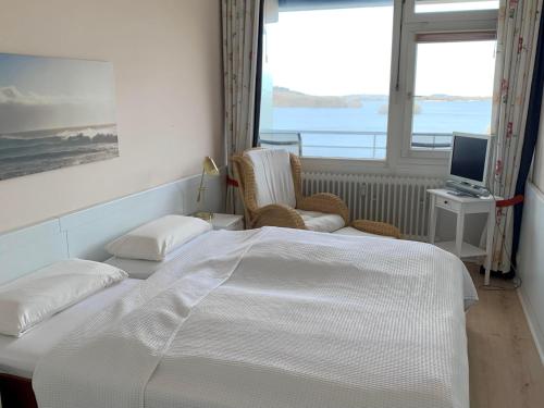 a bedroom with a bed and a television and a window at Appartement Seesicht in Malente