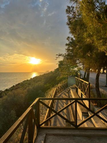 a staircase leading to the beach with a sunset in the background at Manti in Skala Marion