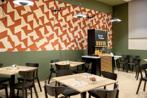a restaurant with tables and chairs and a geometric wall at DWO Valencia in Valencia