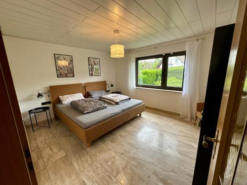 a bedroom with a bed in a room with a window at Schöne Wohnung mit großem Garten in Stockach